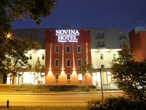 Außenansicht des Hotels Tillypark bei Nacht mit beleuchtetem Eingangsbereich und umgebender Vegetation